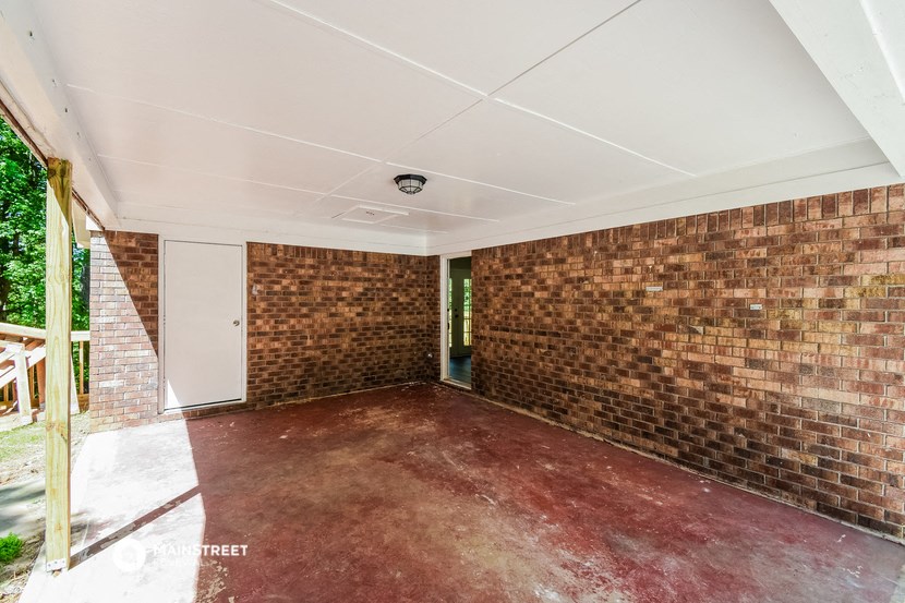 an empty room with brick walls and a red carpet