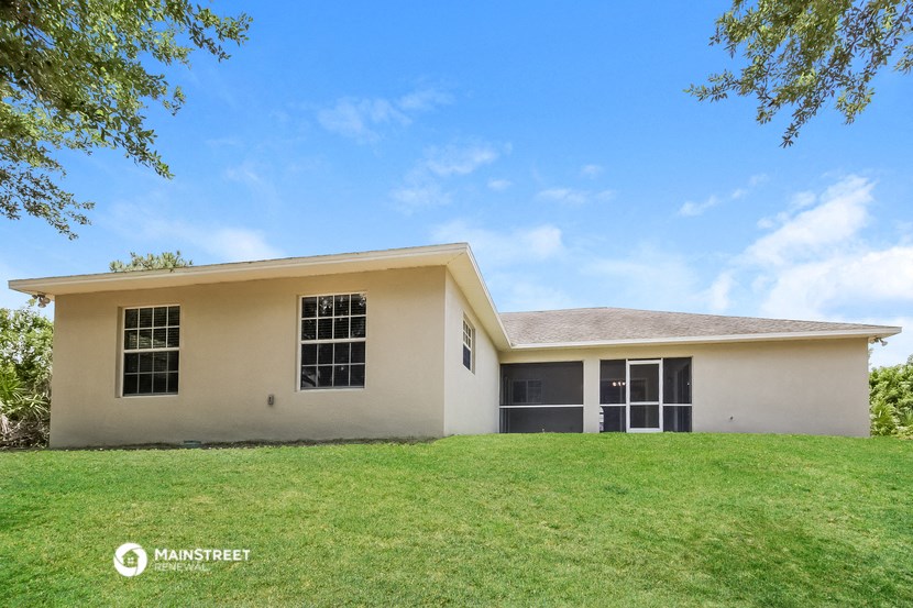 a white house with a grassy yard and a blue sky