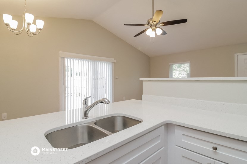 a kitchen with a sink and a ceiling fan