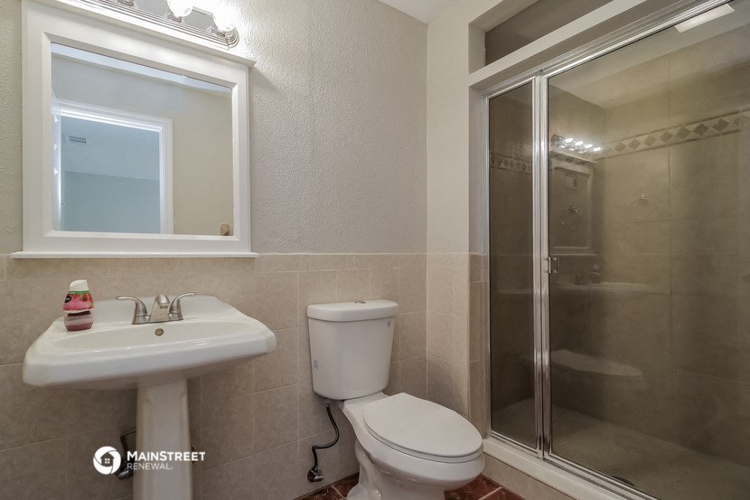 a bathroom with a toilet and a sink and a shower