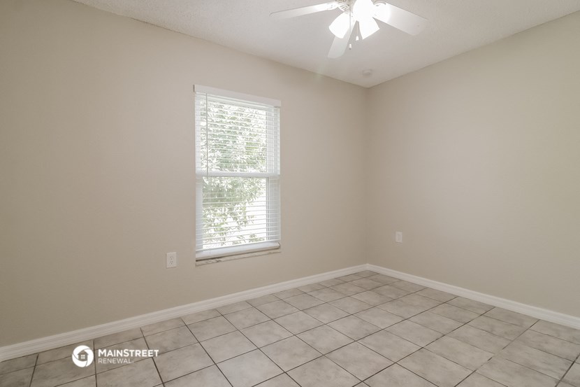 an empty room with a window and a tiled floor