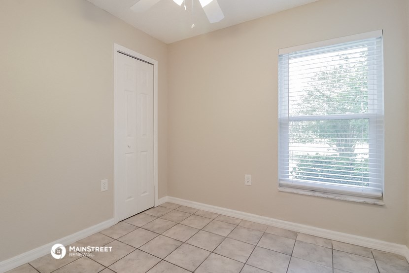 a room with a window and a door and a tiled floor