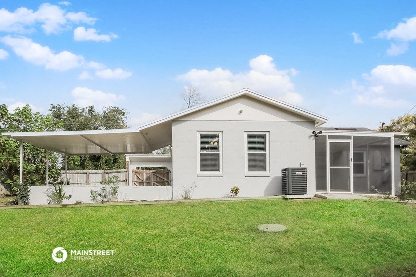 a white house with a grass yard and a roof