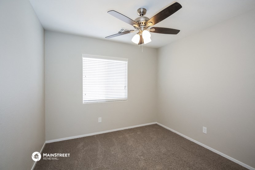 a bedroom with a ceiling fan and a window