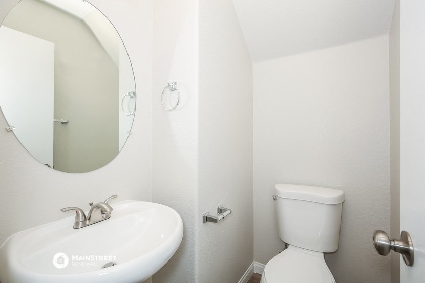a bathroom with a toilet and a sink and a mirror
