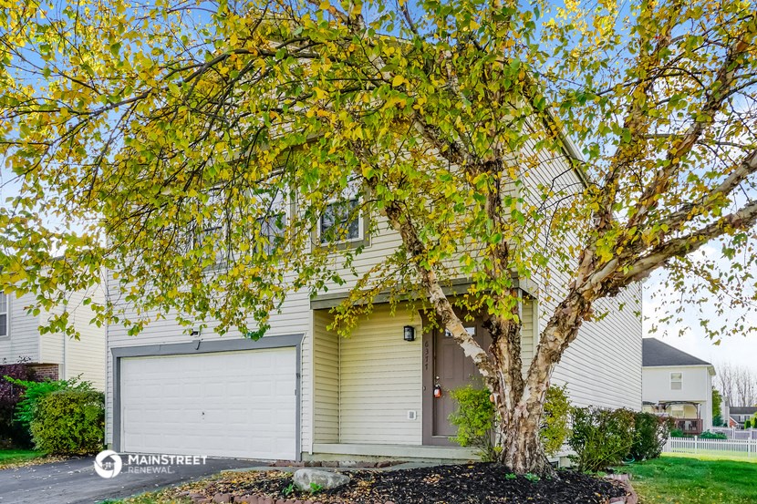 a yellow house with a tree in front of it