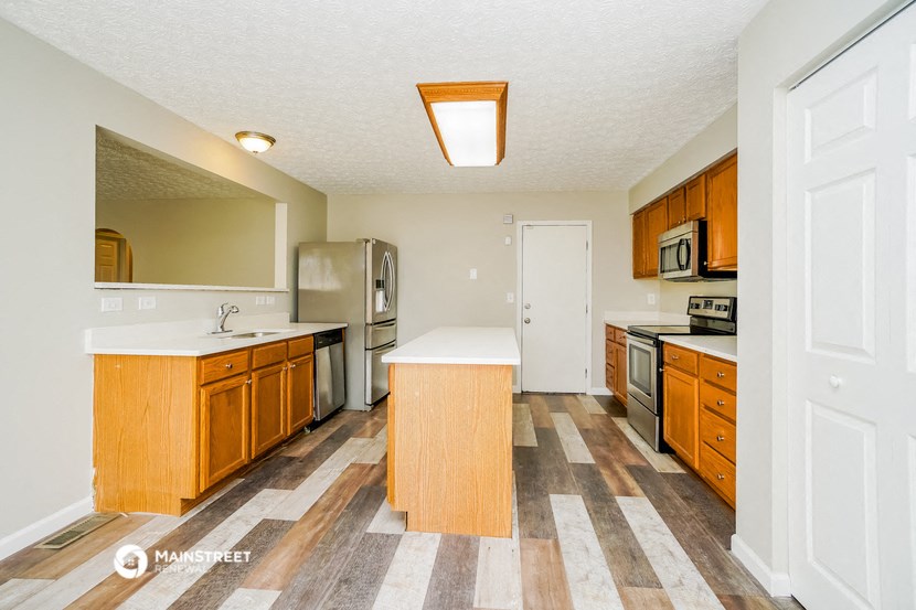 a kitchen with wooden cabinets and stainless steel appliances