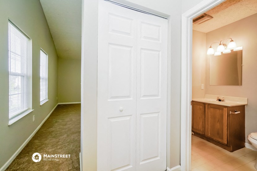 a bathroom with a white door and a sink and a toilet