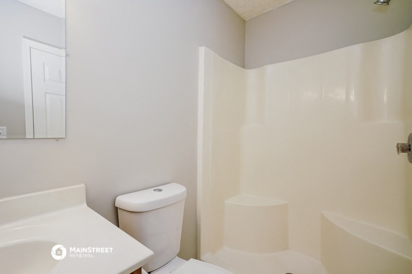 a bathroom with a toilet and a tub and a sink