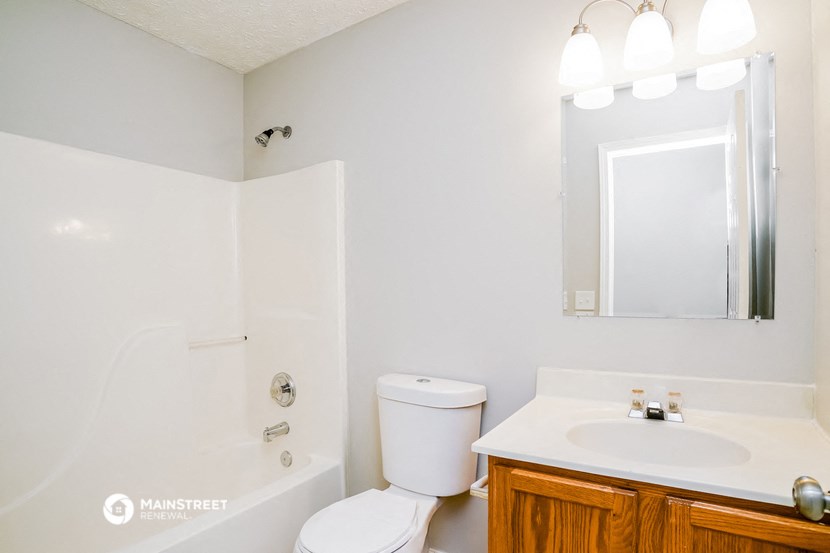 a bathroom with a sink toilet and shower and a mirror