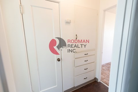 A white door with Rodman Realty Inc. logo on it.