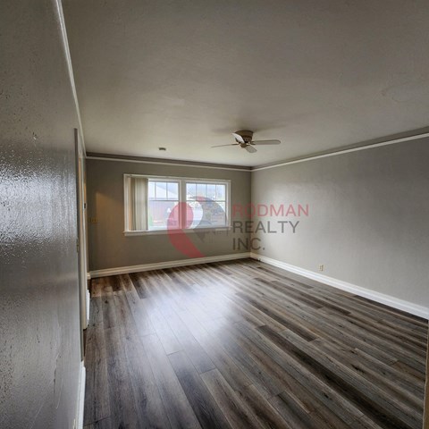 A room with a wooden floor and a ceiling fan.