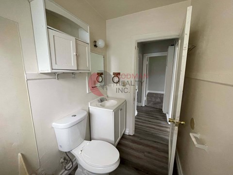 A white toilet and sink in a small bathroom.