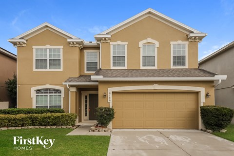 a beige house with a garage door and a lawn