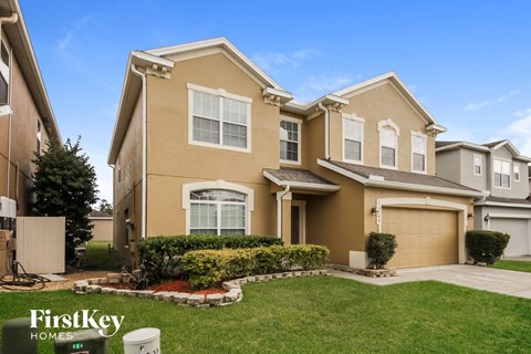 a beige house with a lawn in front of it