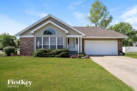 a home with a lawn and a white garage door