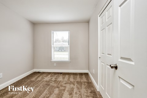 a bedroom with carpeted floors and a window