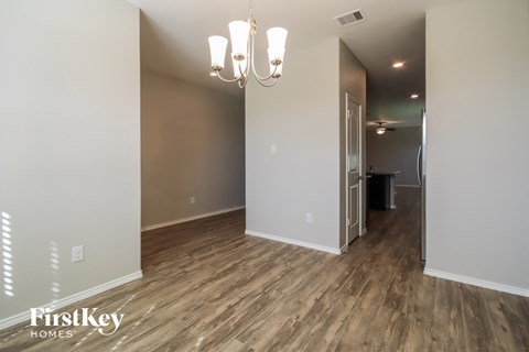 a living room and hallway with wood flooring and a chandelier