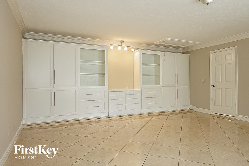 a large room with white cabinets and a tile floor