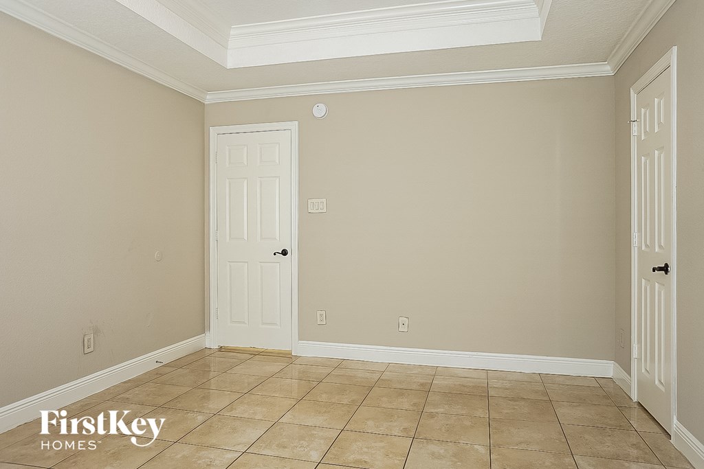 the living room of a home with a tile floor and a white door