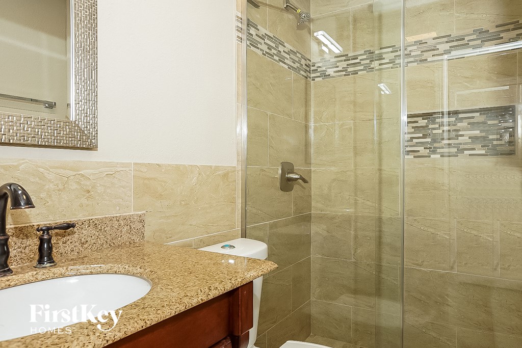 a bathroom with a shower and a sink and a mirror