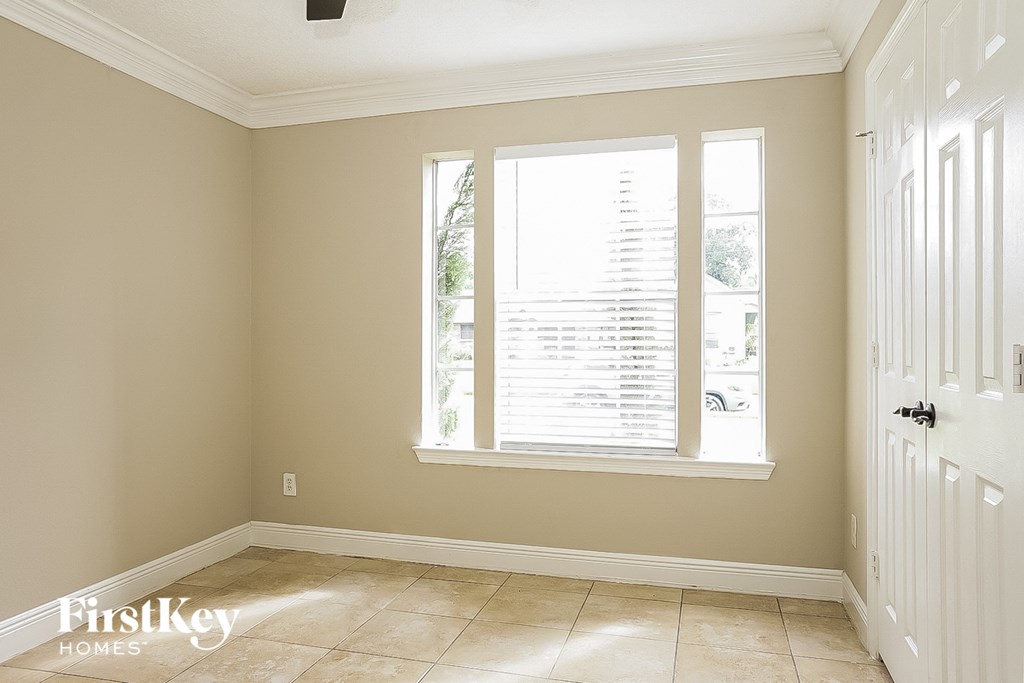 a room with a window and a door and a tiled floor
