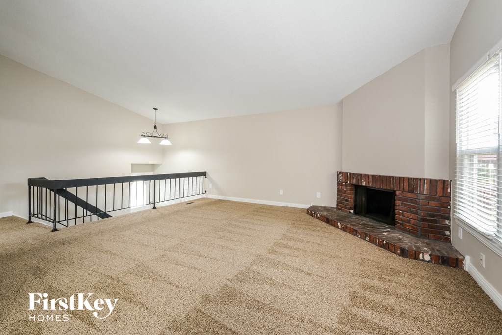 A living room with a fireplace and a carpet.