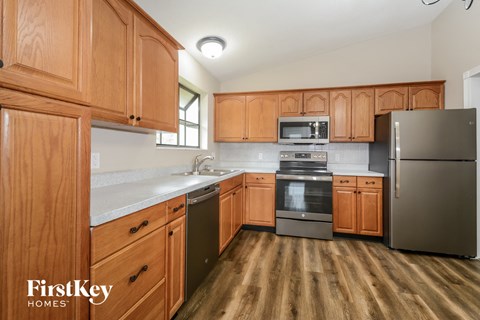 A kitchen with wooden cabinets and a refrigerator.