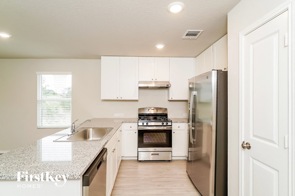 A kitchen with white cabinets and stainless steel appliances.
