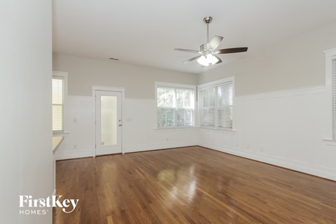 a living room with wood floors and a ceiling fan
