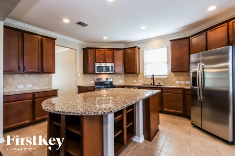 A kitchen with brown cabinets and a granite countertop.