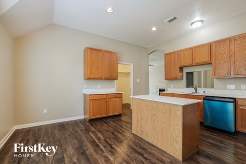 a kitchen with wood flooring and wooden cabinets and a blue dishwasher