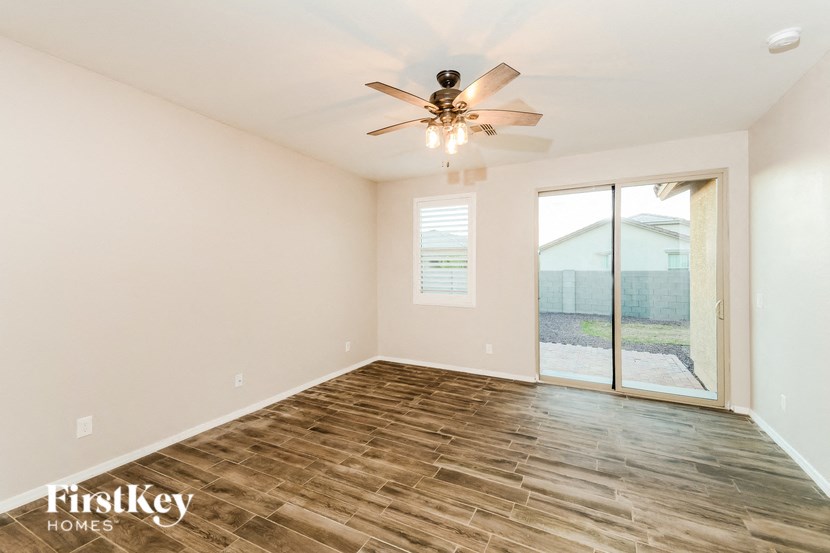 A room with wooden flooring and a ceiling fan.