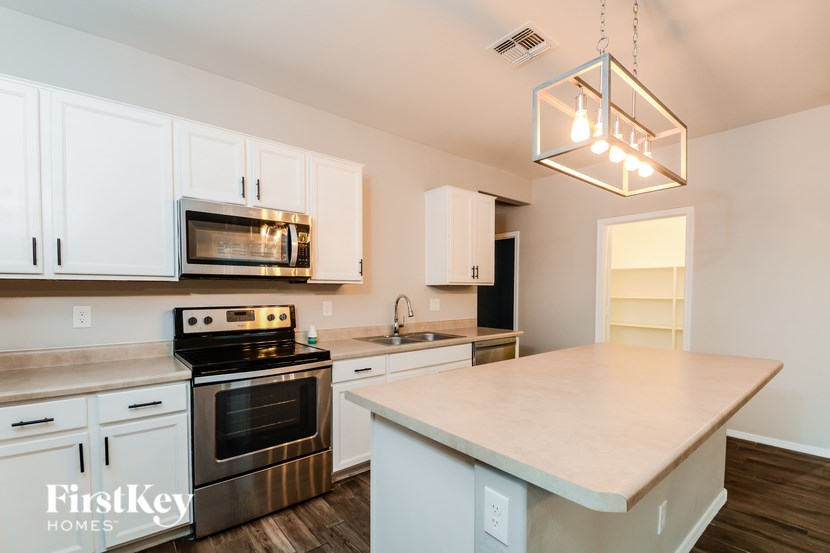 A kitchen with a stove, oven, and cabinets.