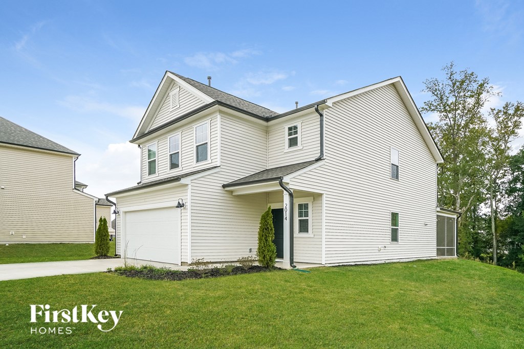 a white house with white siding and a green lawn