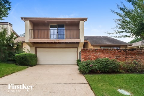 a house with a white garage door in front of a lawn