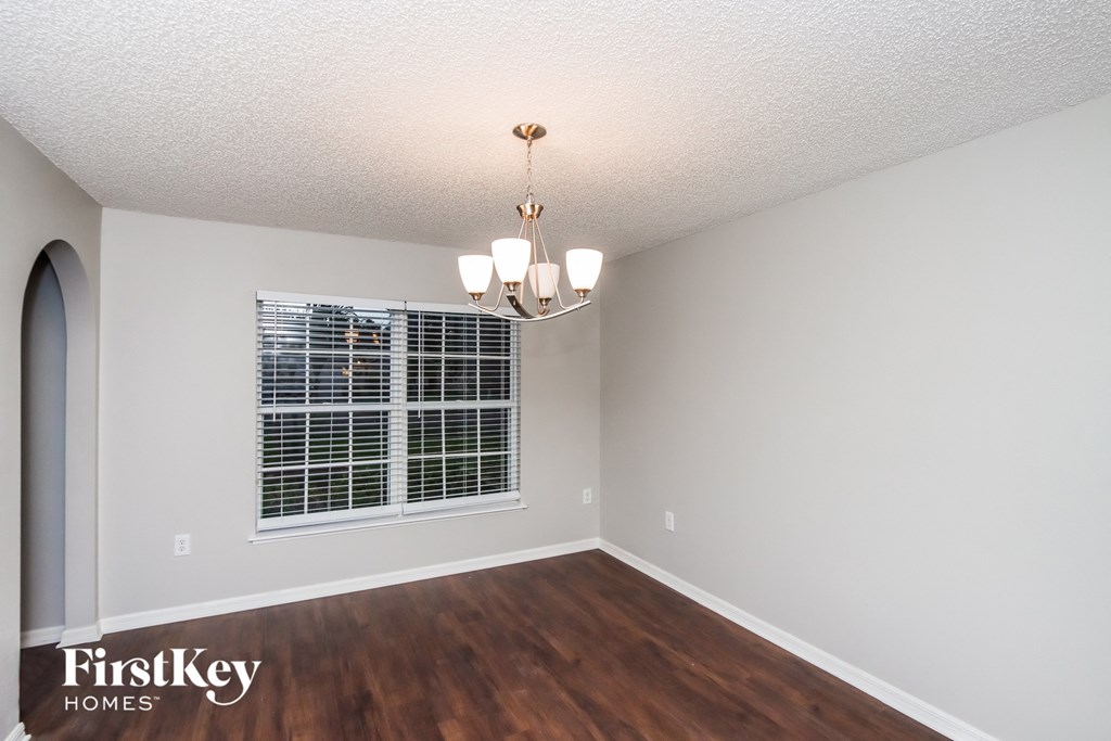 A room with a window and a chandelier.