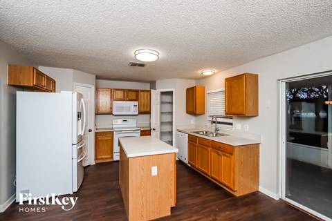 A kitchen with wooden cabinets and a white refrigerator.