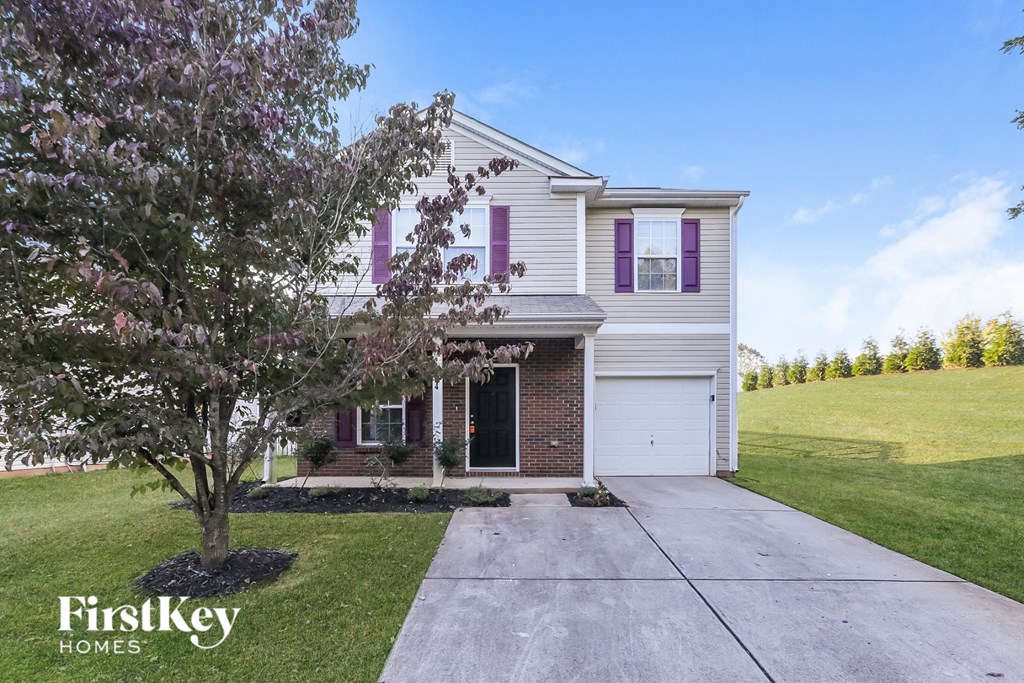 a white and brick house with purple shutters and a sidewalk