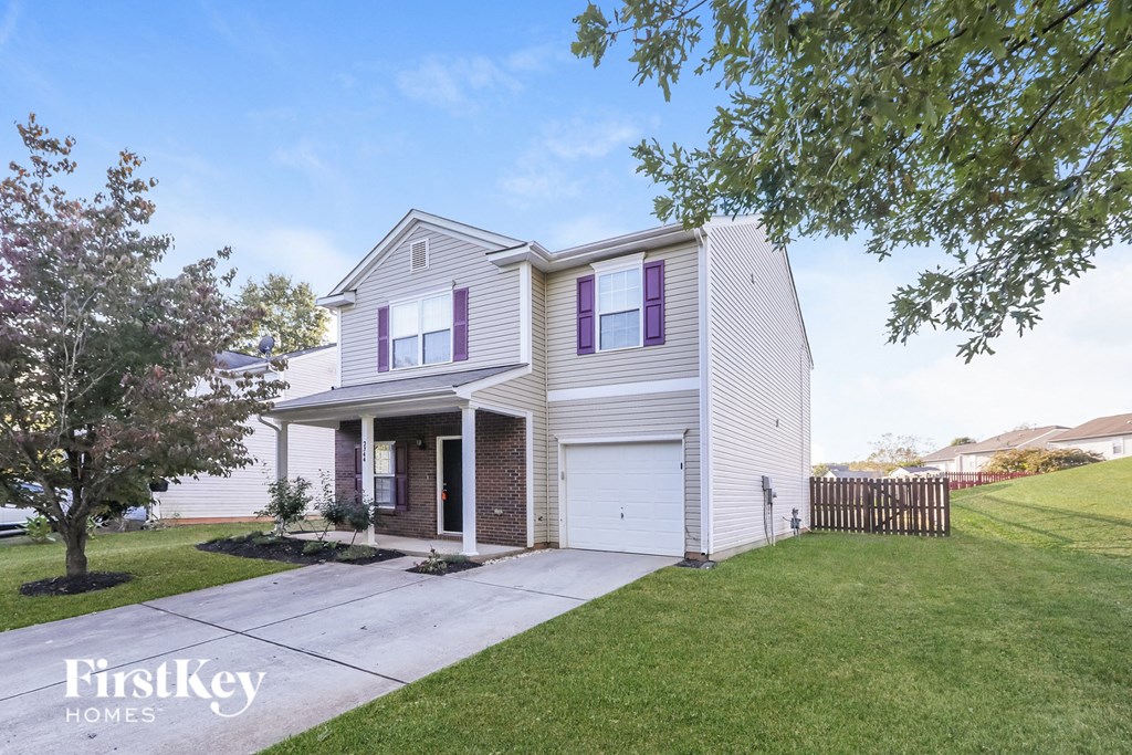 a white house with purple window shutters and a driveway