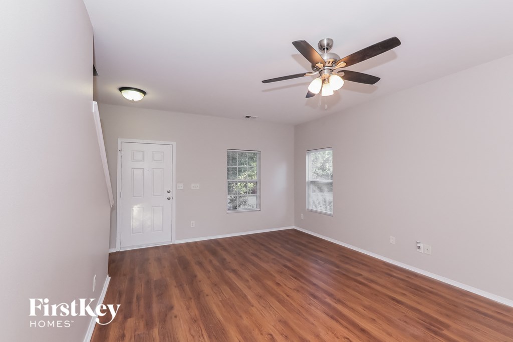 a living room with hardwood floors and a ceiling fan