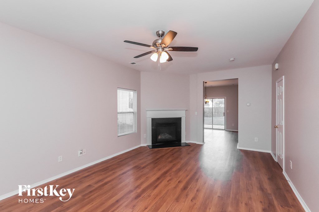 a living room with a ceiling fan and a fireplace