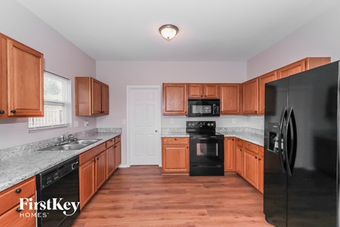 a kitchen with black appliances and wooden cabinets