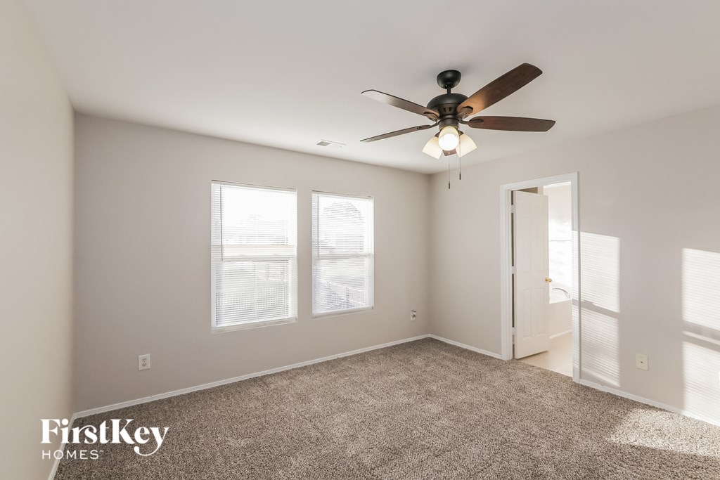 the master bedroom has a ceiling fan and a carpeted floor