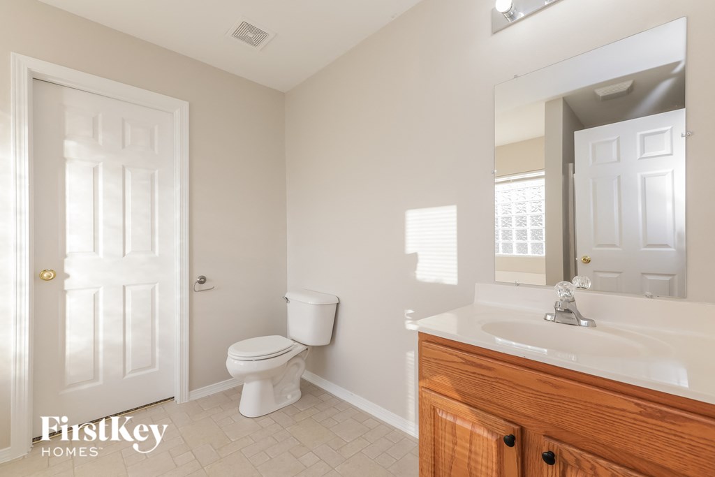 a bathroom with a toilet and a sink and a mirror