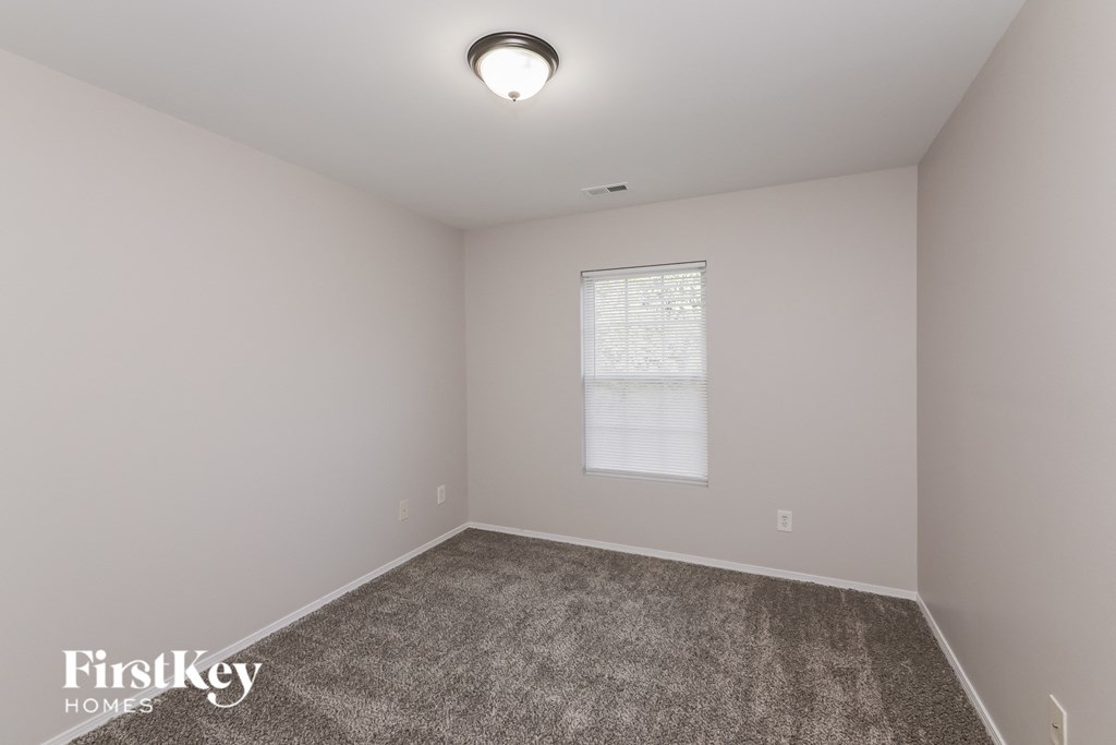 a bedroom with a carpeted floor and a window