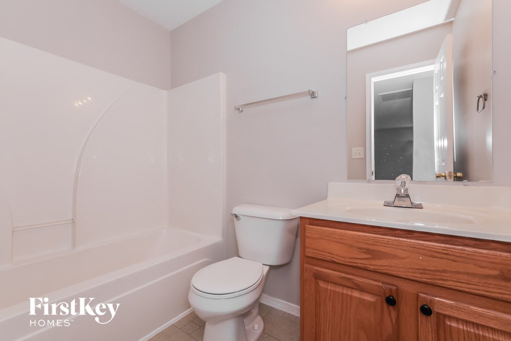a bathroom with a toilet and a sink and a bath tub