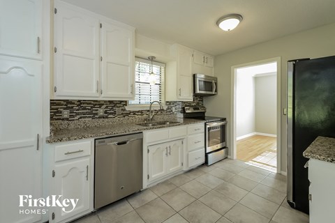 A kitchen with white cabinets and a granite countertop.