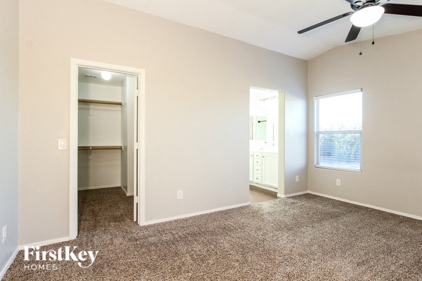 a living room with carpet and a ceiling fan