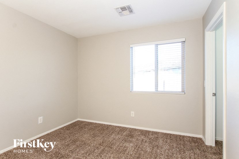 a bedroom with a carpeted floor and a window